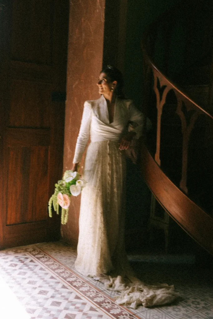Close-up of a minimalist and elongated bridal bouquet featuring sculptural white and pink anthuriums, hydrangeas, and trailing green amaranthus. Bespoke spring floral design for a destination wedding at Quinta do Outeiro by Mande uma Flor.